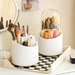 Rotating makeup brush holder with dustproof lid on white vanity table holding 25 makeup brushes