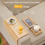 Bamboo sofa arm tray with coffee mug and mobile phone on grey couch