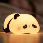 Silicone sleeping panda night lamp glowing warmly in dark kids bedroom